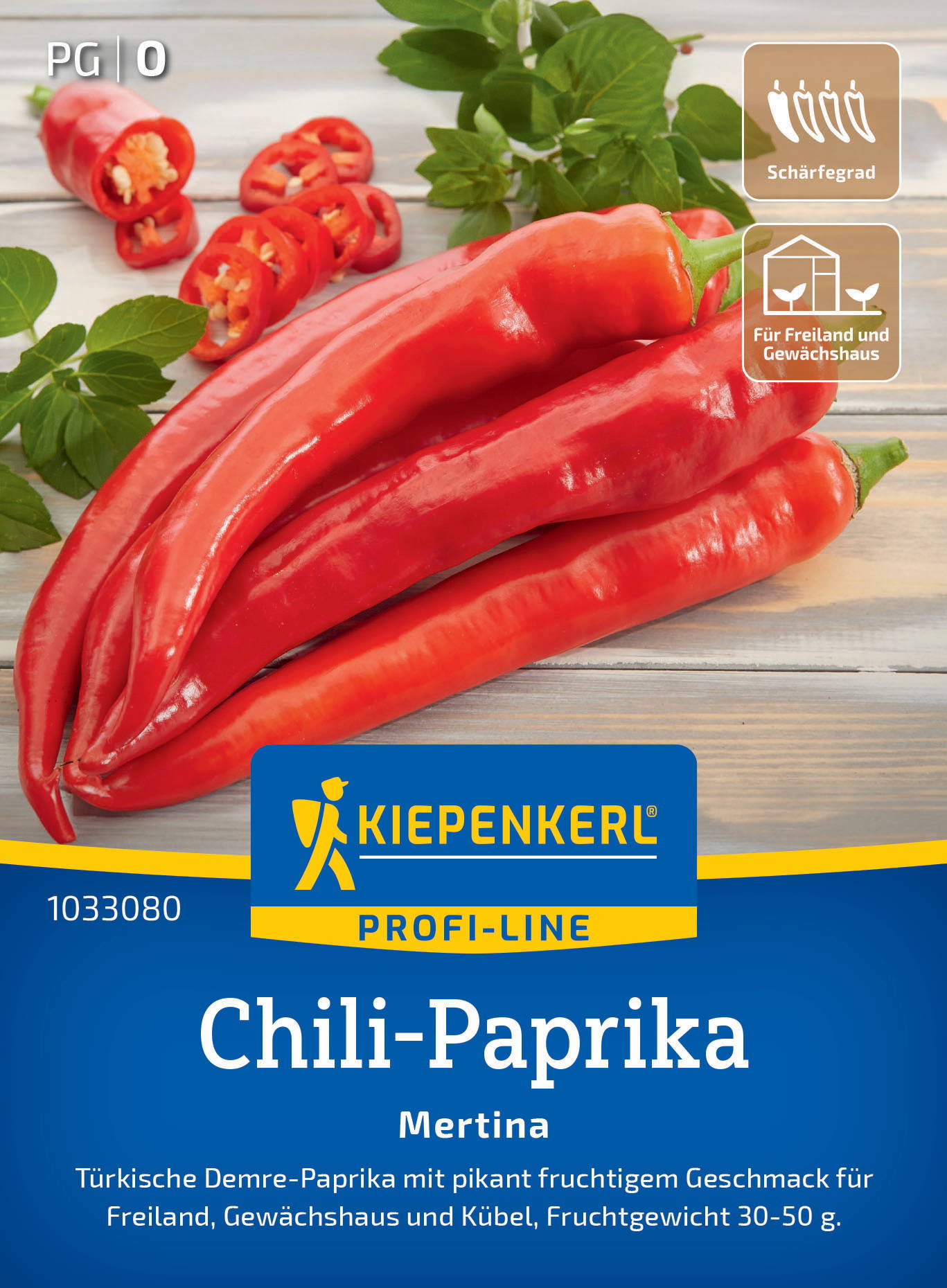 Rote Chili-Paprika, einige geschnitten, grüner Basilikum im Hintergrund, auf hellem Holztablett.