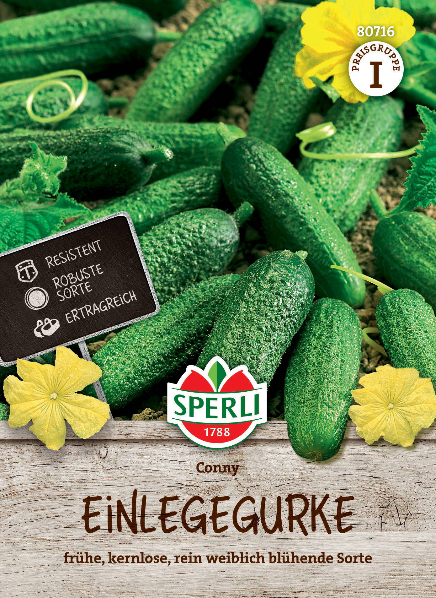 Gurken liegen auf Erde, gelbe Blüten und ein Schild mit Produktinformationen sind sichtbar.