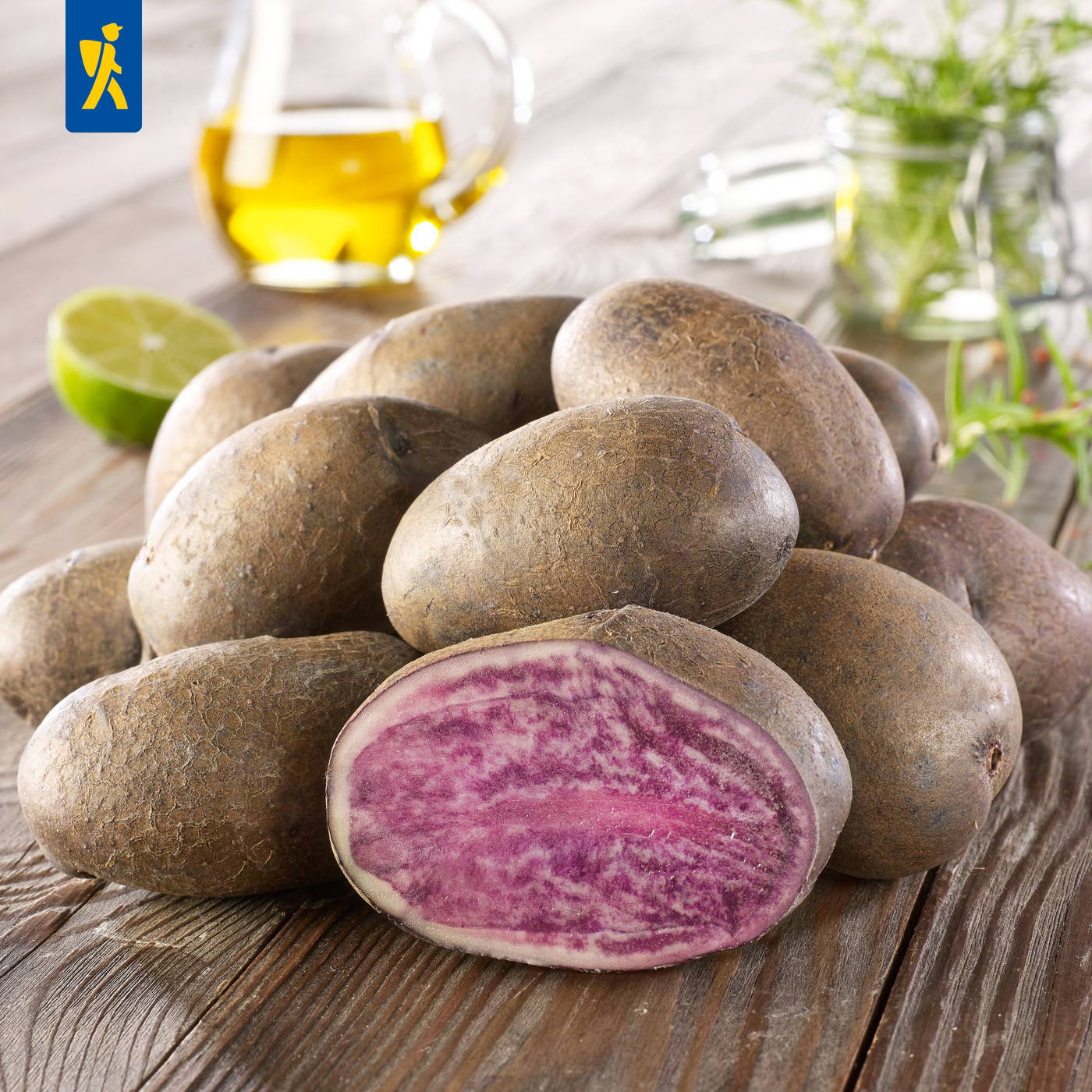 Holztablett mit roter und weißer Radieschen, Zitrone, Ölflasche und Kräuter hinter Glas.