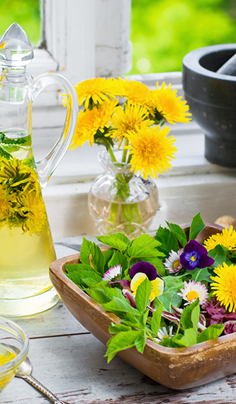 Bunter Blumentopf mit gelben und violetten Blumen auf einer weißen Fensterbank.