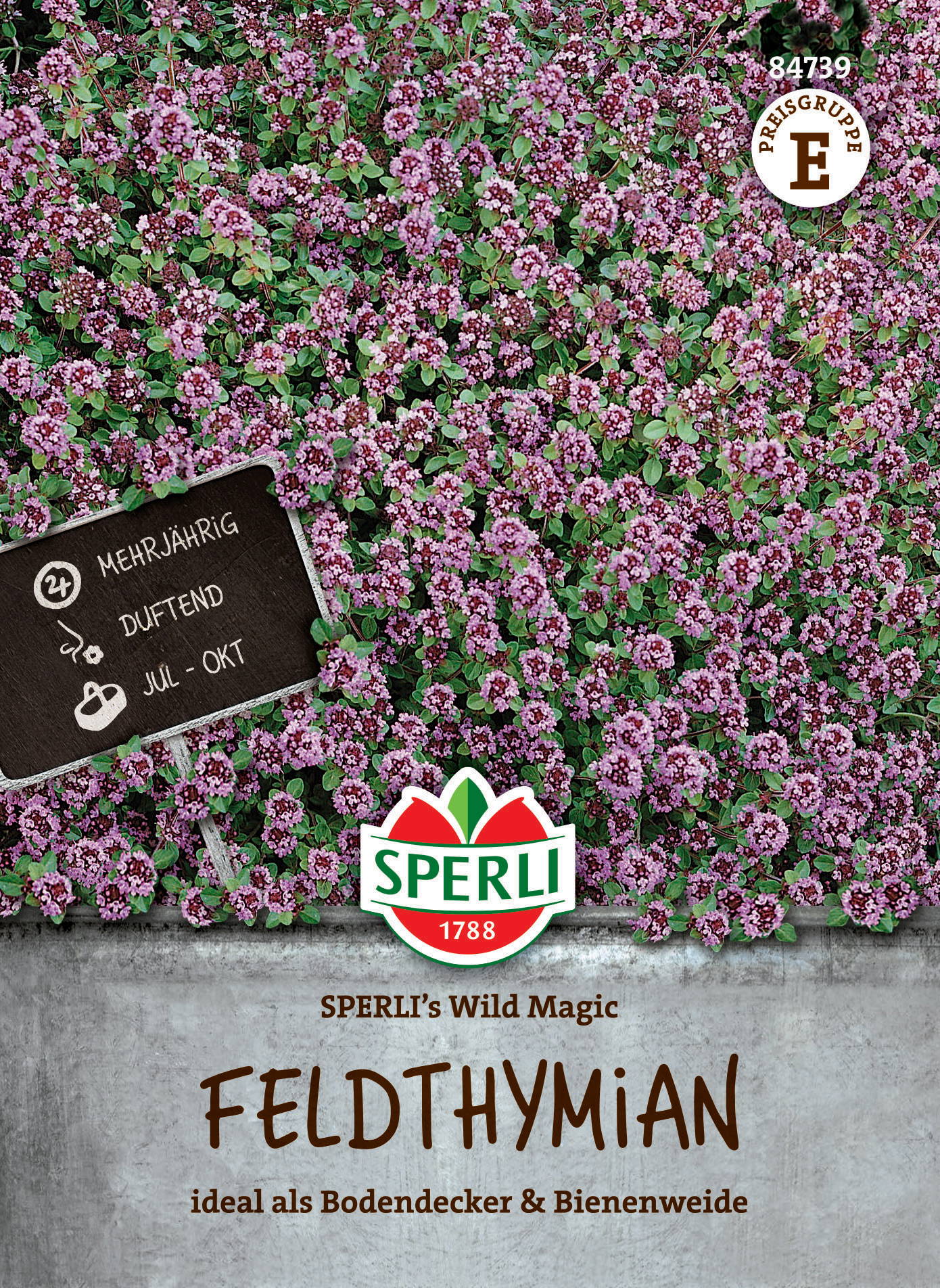 Voll mit kleinen pinken Blüten bedeckter Boden mit einem schwarzen Schild, Sperli Logo und Text.