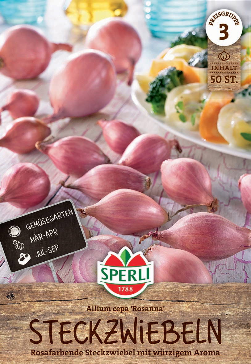 Rosa Zwiebeln auf einer Holzoberfläche mit einem Teller gefüllter Rosenzwiebeln im Hintergrund.