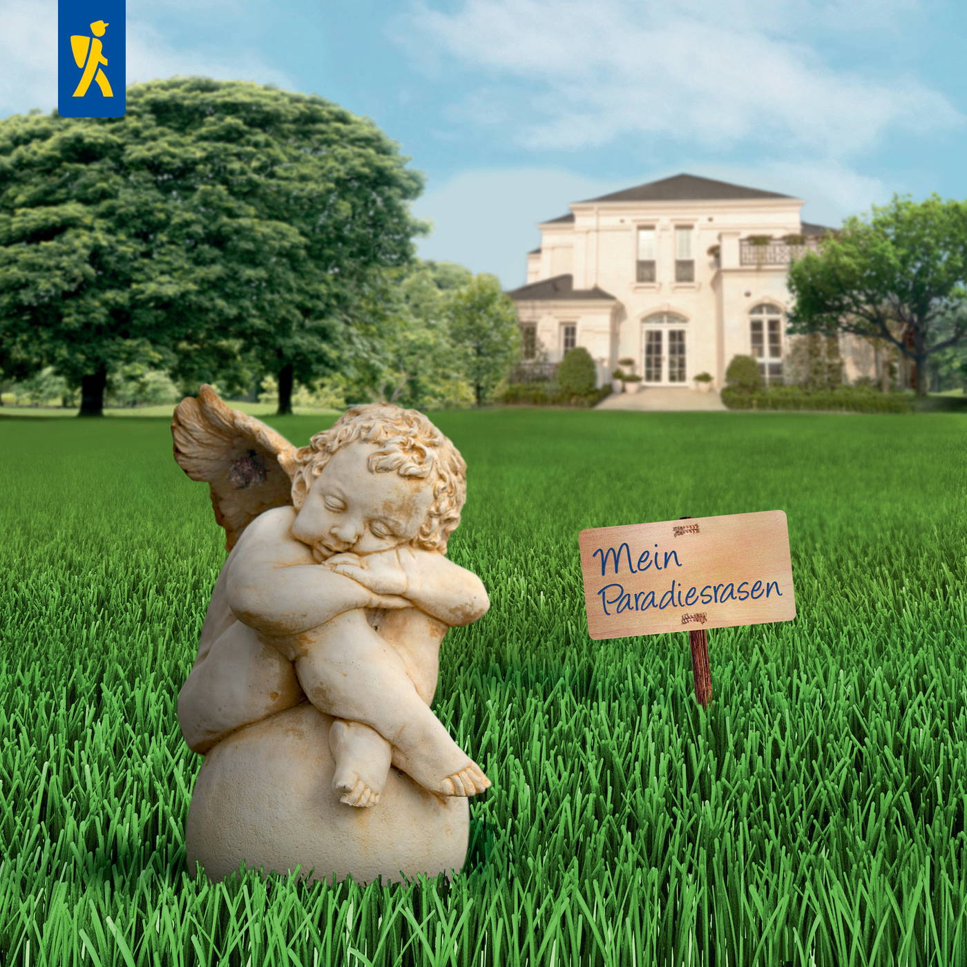 Kleiner geschnitzter Engel mit gefalteten Händen und Flügeln auf grünem Rasen vor großem weißen Haus.